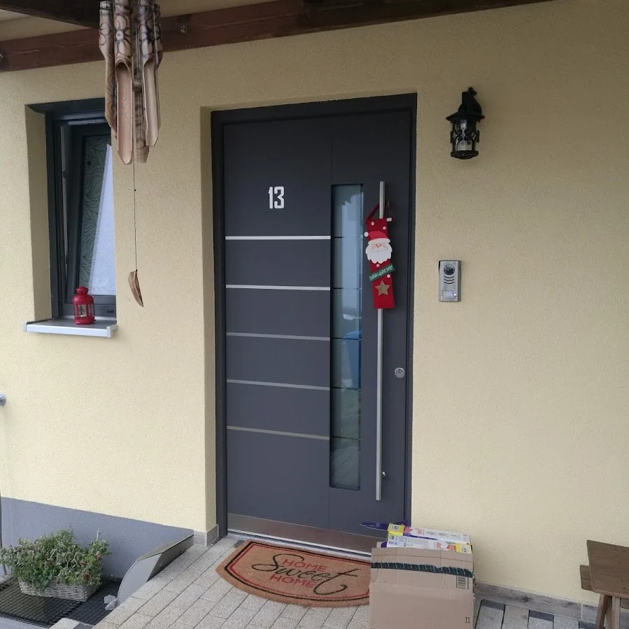 Anthrazitfarbene Haustür mit Edelstahl-Querlinien