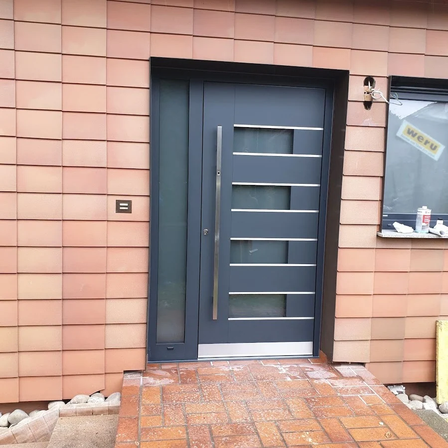 Anthrazitfarbene Haustür mit Glasstreifen an Klinkerfassade