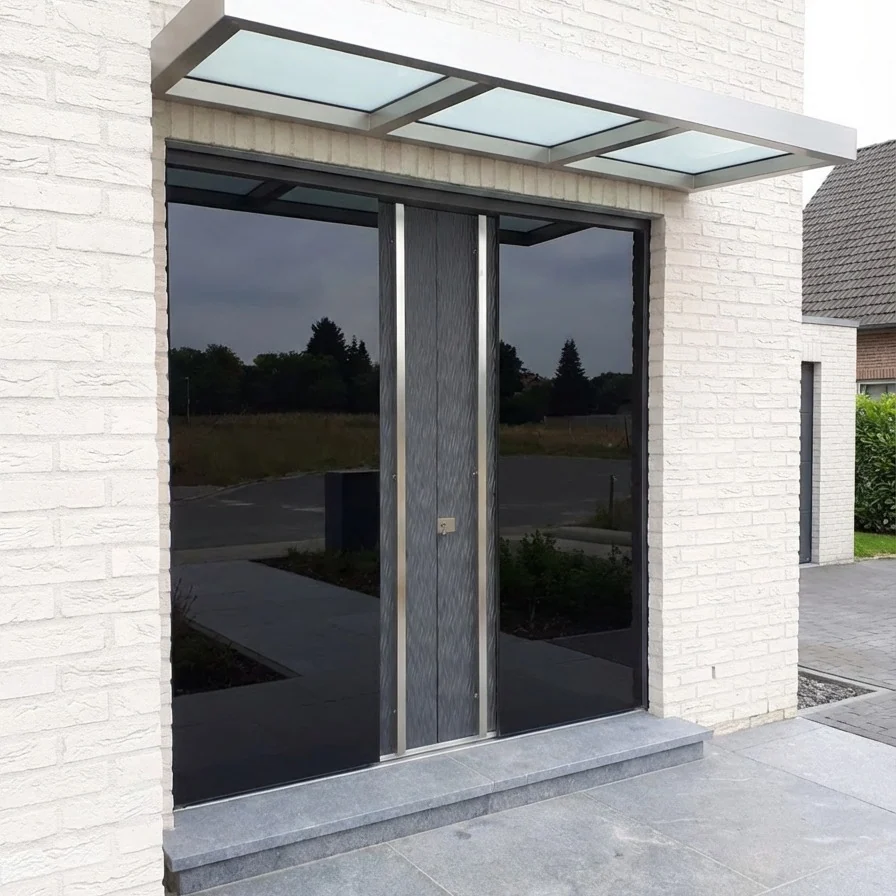 Dunkle Glas-Eingangsanlage an heller Klinkerfassade