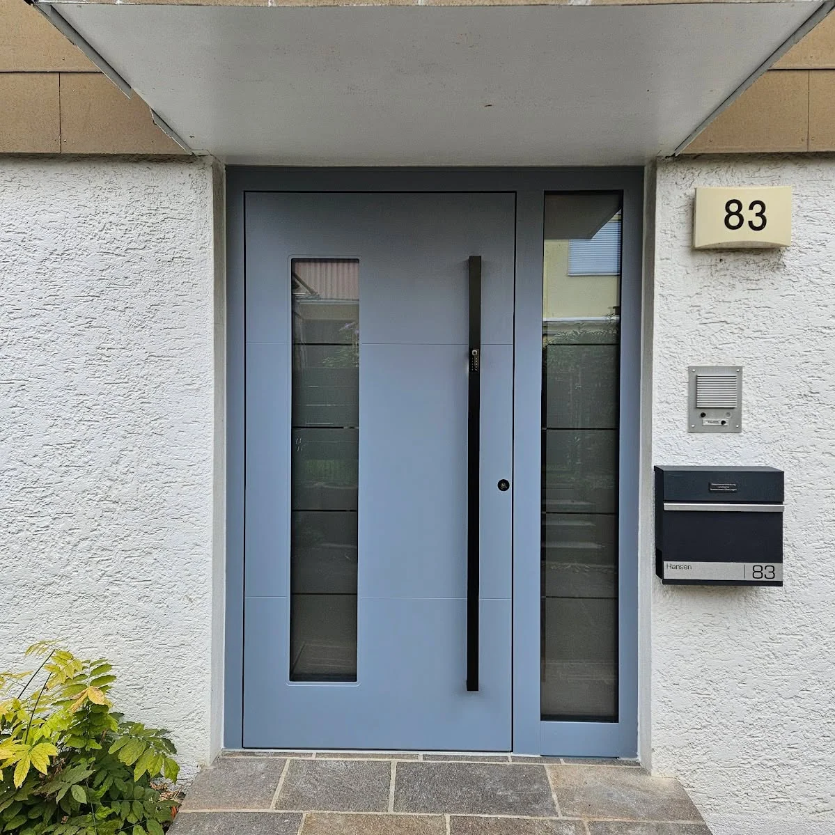 Graue Haustür mit schmalem Glasfeld und Seitenteil