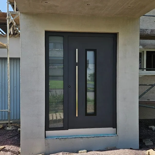 Graue Inotherm Haustür mit Seitenteil im Rohbau