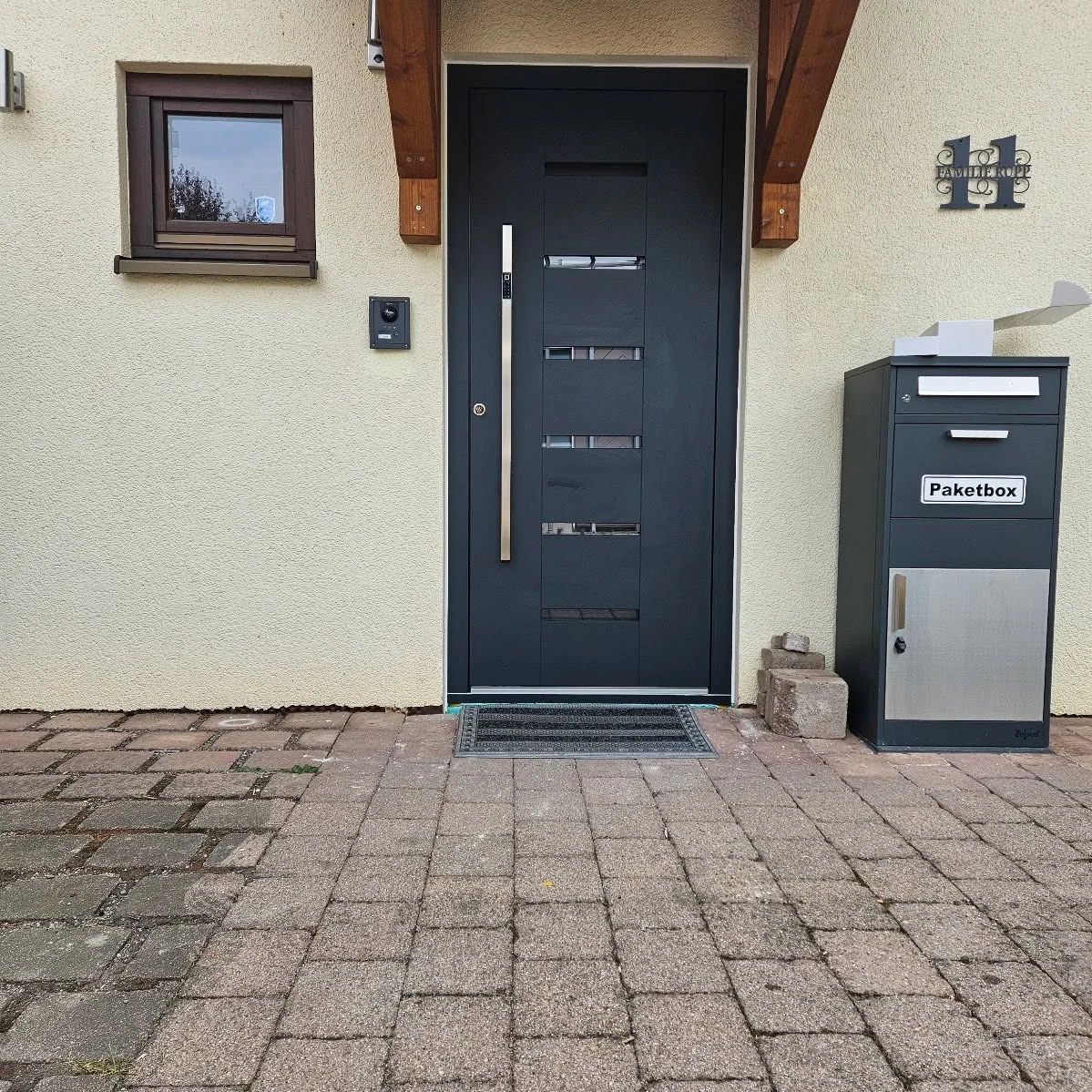 Inotherm-Haustür in Anthrazitgrau mit vier horizontalen Glasstreifen und Holzdekor-Einsatz