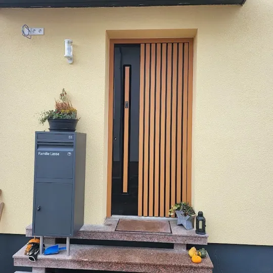 Aluminium-Haustür in RAL 7016 Anthrazitgrau mit vertikalen Eiche-Holzlamellen und schmalem Glasstreifen