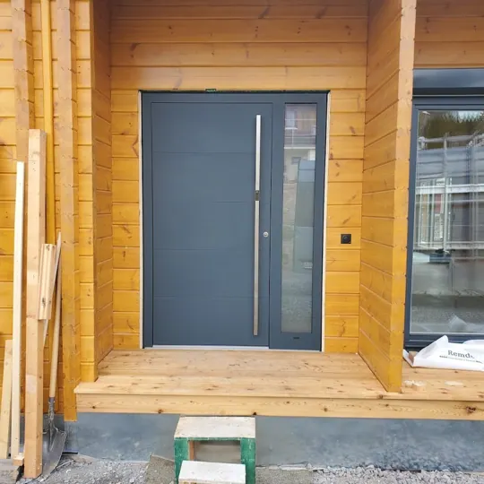 Anthrazit-Haustür im Holzhaus mit Seitenteil