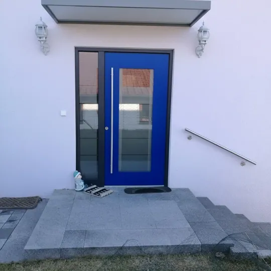 Blaue Haustür mit großem Glasfeld und Seitenteil