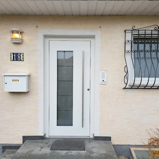 Inotherm Exclusiv Aluminium-Haustür in RAL 9016 Verkehrsweiß mit vertikalem Glasausschnitt und Sprossen-Motivglas