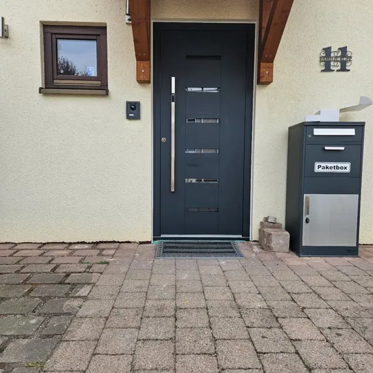 Inotherm-Haustür in Anthrazitgrau mit vier horizontalen Glasstreifen und Holzdekor-Einsatz