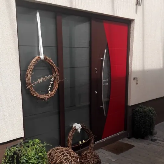 Rote Haustür mit geschwungenem Edelstahlgriff