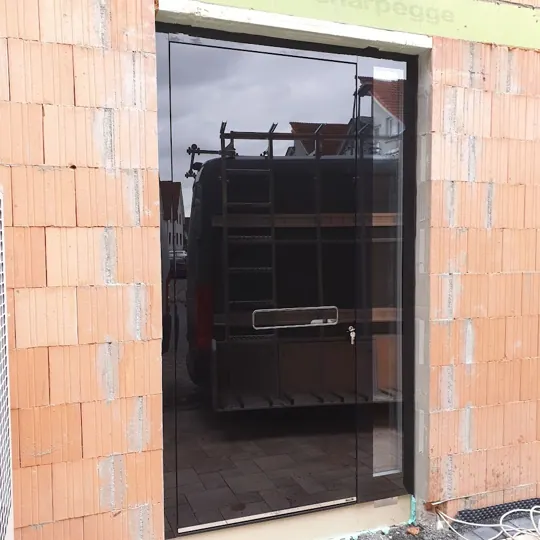 Schwarze Glas-Haustür im Rohbau