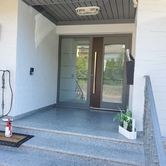 Verglaste Eingangsanlage unter einer Überdachung