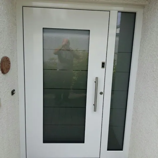 Weiße Haustür mit großem Glasfeld und schmalem Seitenteil
