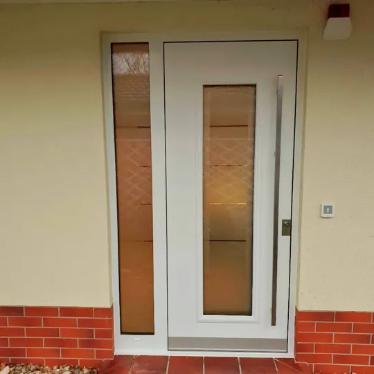 Weiße Haustür mit Seitenteil und Ornamentglas